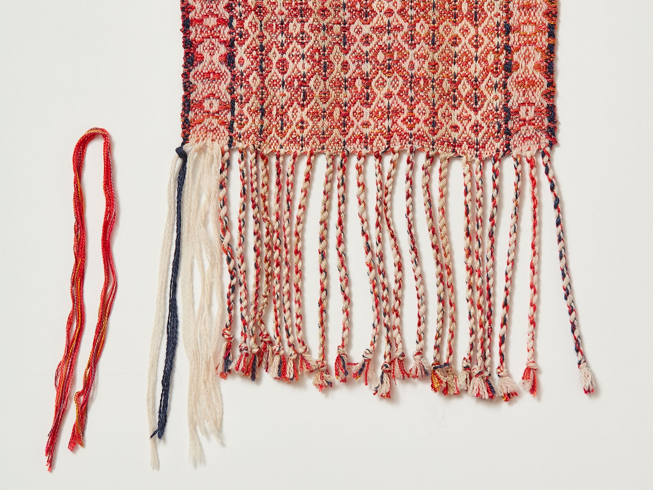 I undid a few of the fringes on this scarf to show that the fringe would be white if I hadn’t added in red weft. Photo credit: George Boe