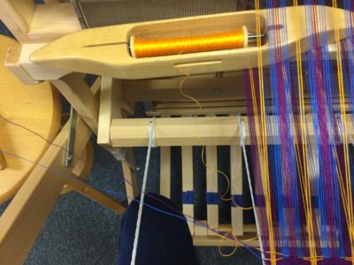 Take the shuttle into the shed over the inactive wefts and floating selvedge.